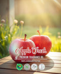 Two red apples on a wooden surface with 'Apple Fresh' fragrance oil packaging.